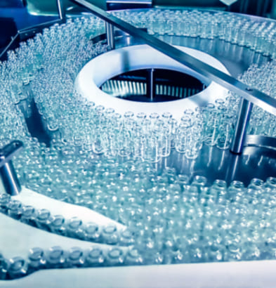 Proceso de producción industrial de viales farmacéuticos en cadena de fabricación automatizada.