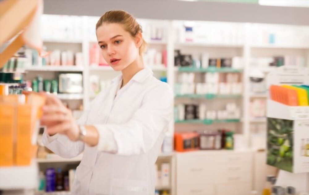 Farmacéutica de Novaltia organizando productos en la farmacia, ofreciendo atención profesional y cercana.